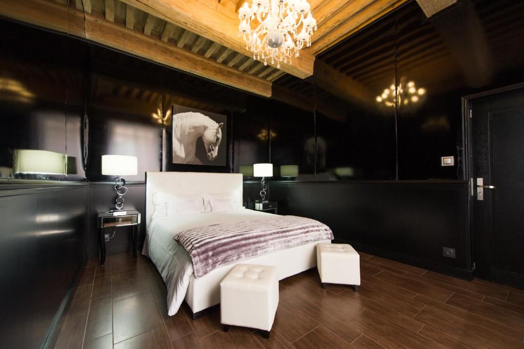 a bedroom with a bed and a chandelier at Aux Portes d'Honneur in Cluny