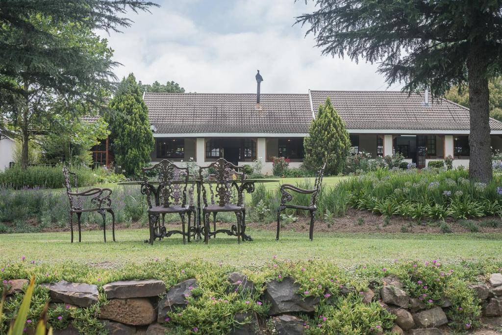 a group of chairs and a table in a garden at Glen Ormond Country House in Rosetta