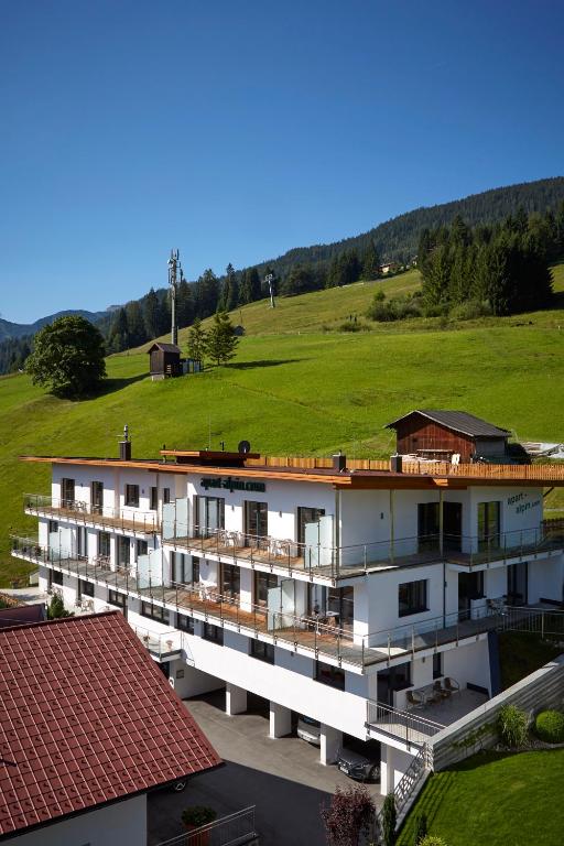 an aerial view of a building with a green field at Apart Alpin in Lermoos