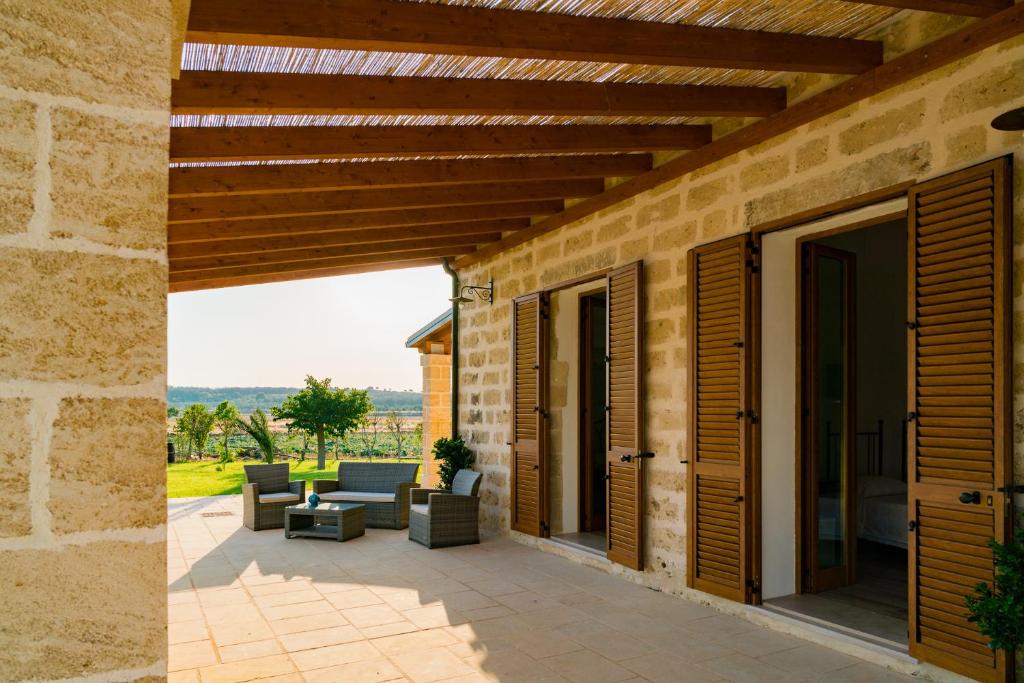 un patio esterno arredato con pergolato in legno di Villa Casale a Cerfignano