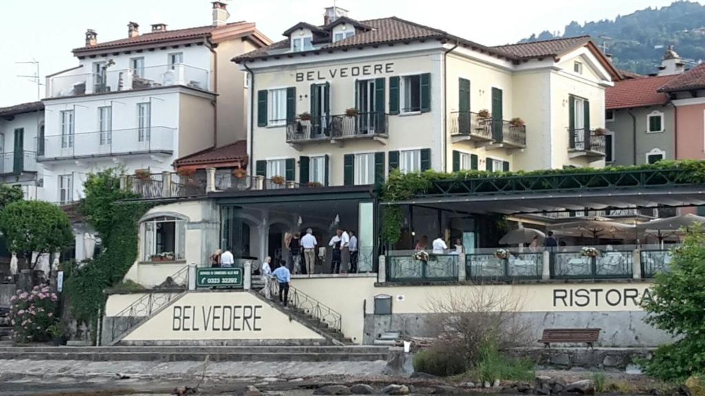 a large white building with people standing on the balcony at Belvedere in Stresa