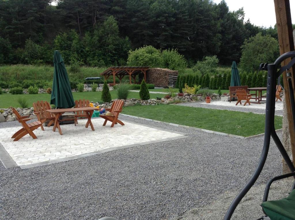 einen Garten mit einem Tisch, Stühlen und Sonnenschirmen in der Unterkunft Ubytovanie Naďka in Turčianske Teplice