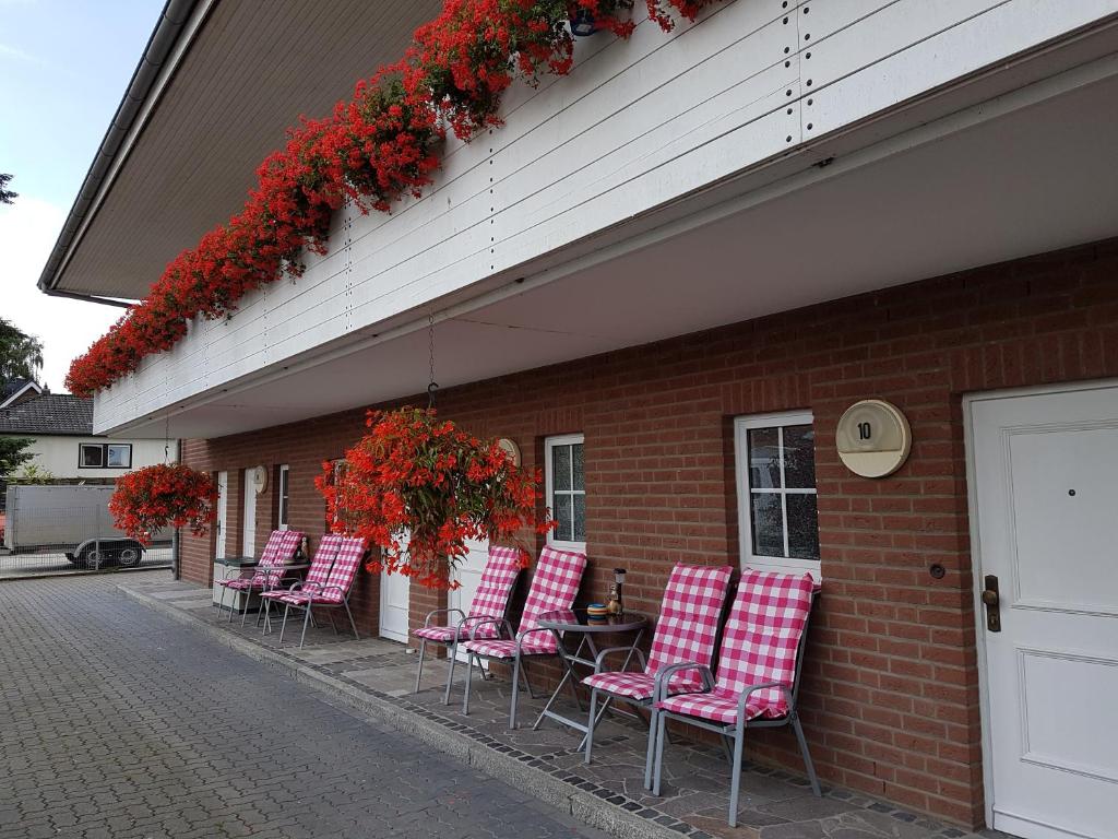 grupa różowych krzeseł i stół na budynku w obiekcie Hotel Steiner w mieście Sehnde