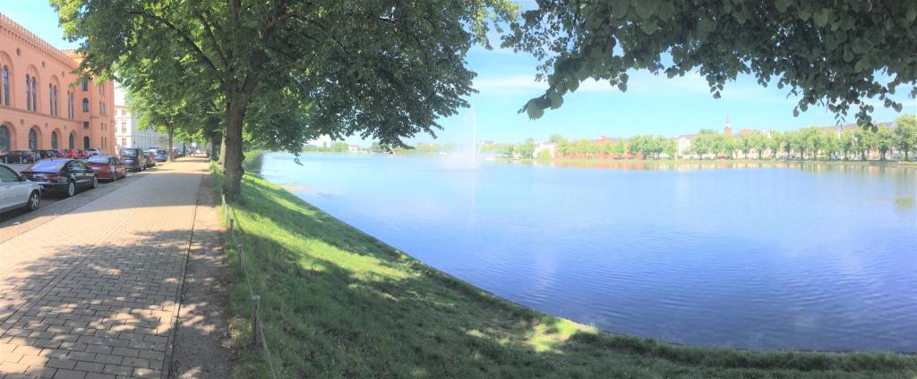 vista su un fiume con auto parcheggiate accanto di Schwerin Apartment am Pfaffenteich a Schwerin