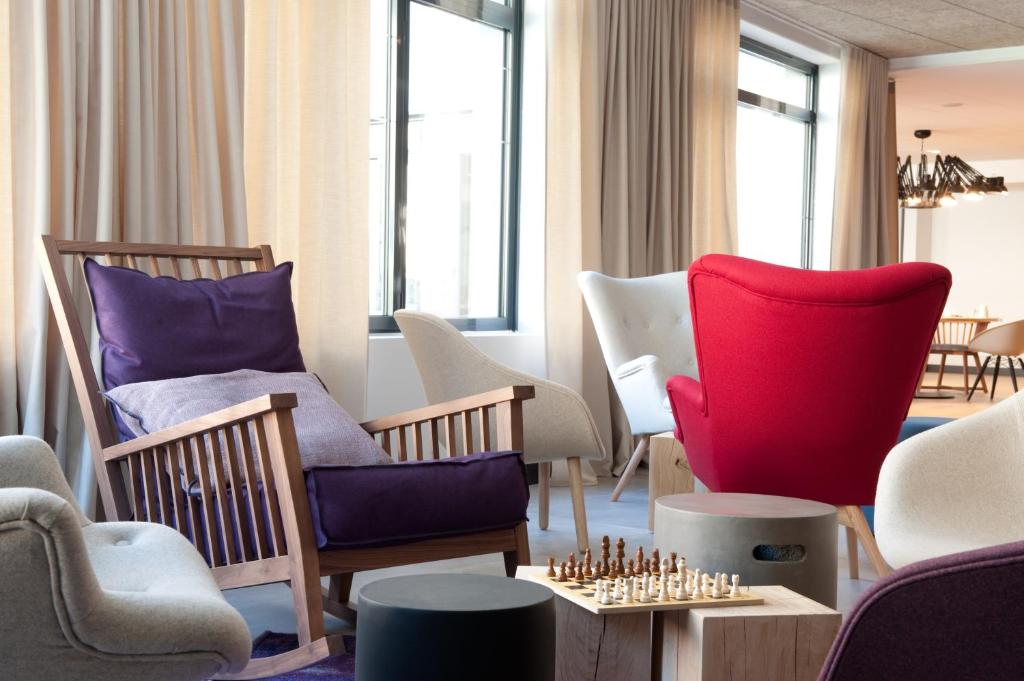 a living room with chairs and a chess board on a table at Campanile Limoges Centre - Gare in Limoges