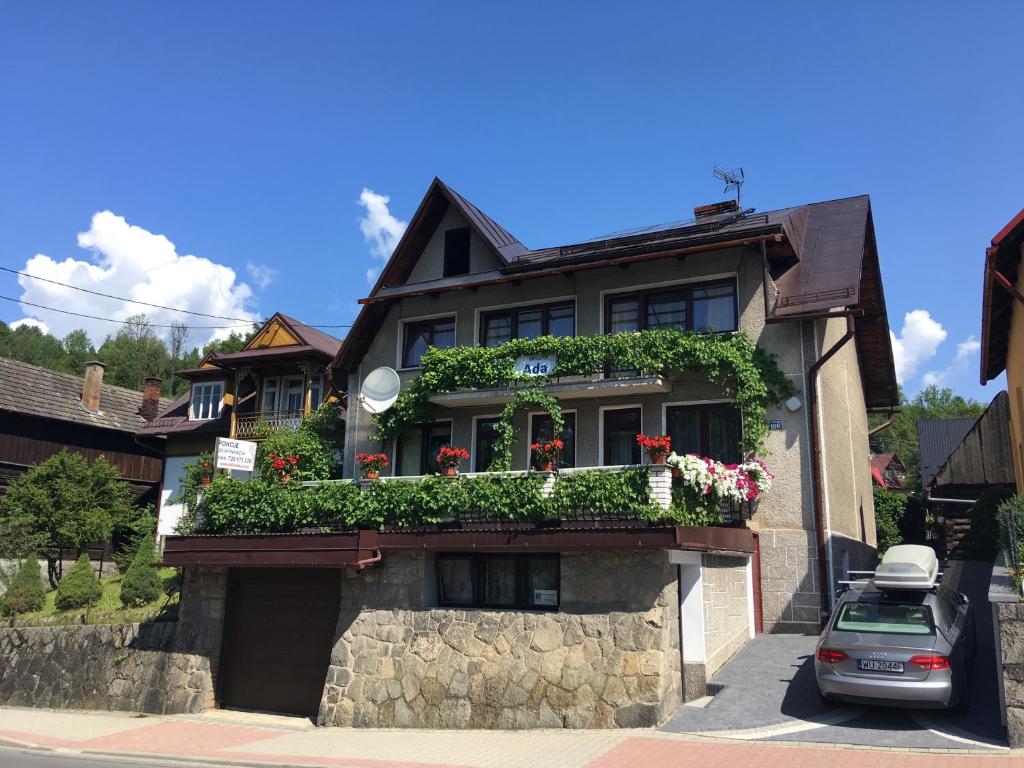 una casa con cajas de flores a un lado. en Willa ADA, en Szczawnica