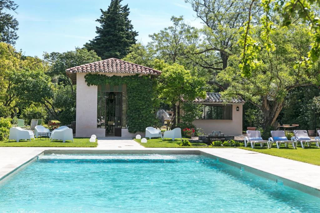 una piscina di fronte a una casa di Hôtel L'Hermitage a Pernes-les-Fontaines