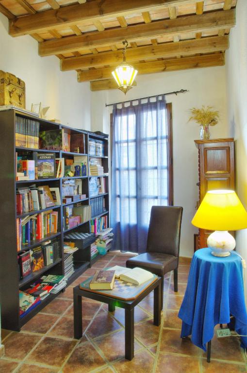 a living room with a chair and a table and bookshelves at Hotel Posada Casas Viejas in Benalup Casas Viejas