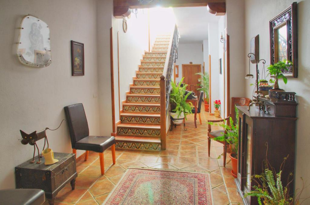 a hallway with stairs and chairs and a stair case at Hotel Posada Casas Viejas in Benalup Casas Viejas