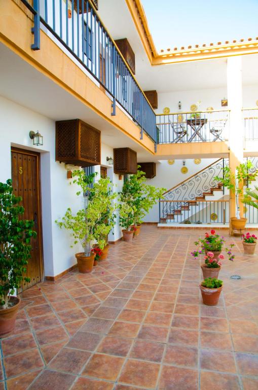 a courtyard with potted plants and stairs in a building at Hotel Posada Casas Viejas in Benalup Casas Viejas