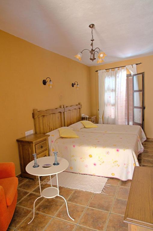 a bedroom with a large bed and a table at Hotel Posada Casas Viejas in Benalup Casas Viejas