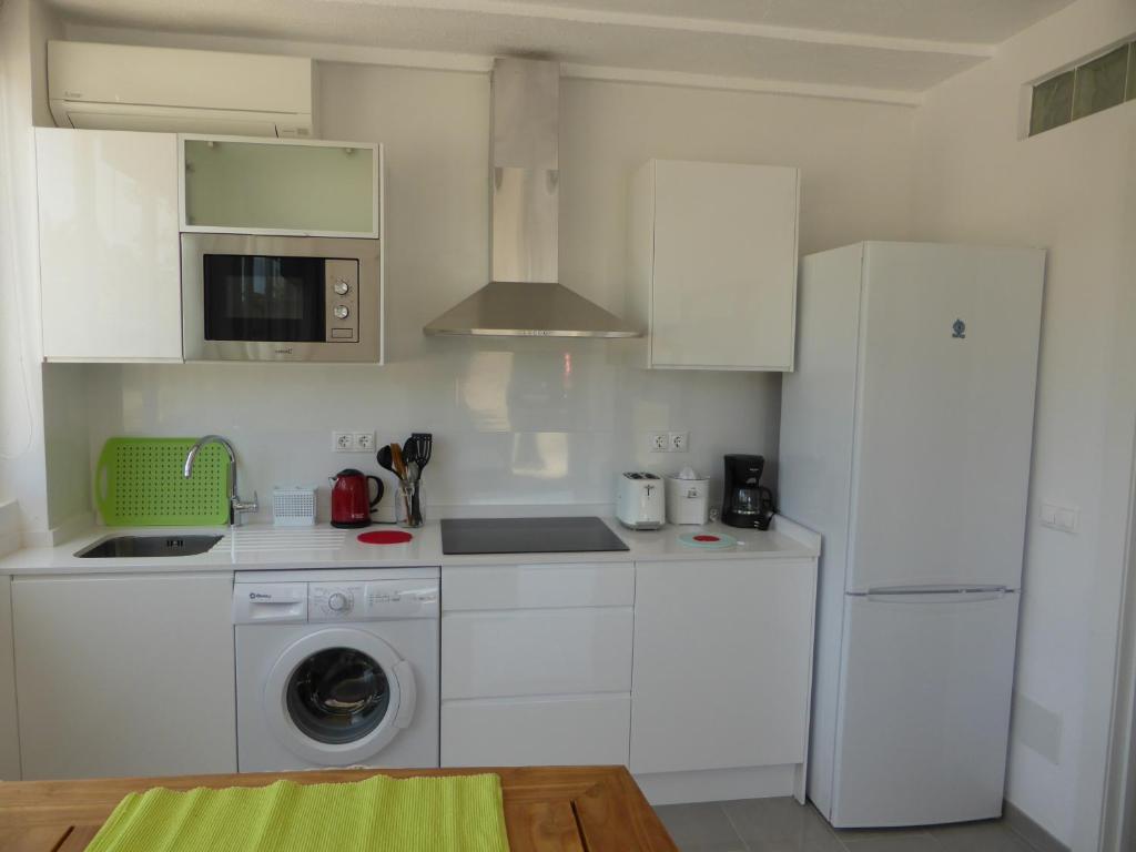 a kitchen with a washing machine and a refrigerator at Casa Jardin in Agua Amarga