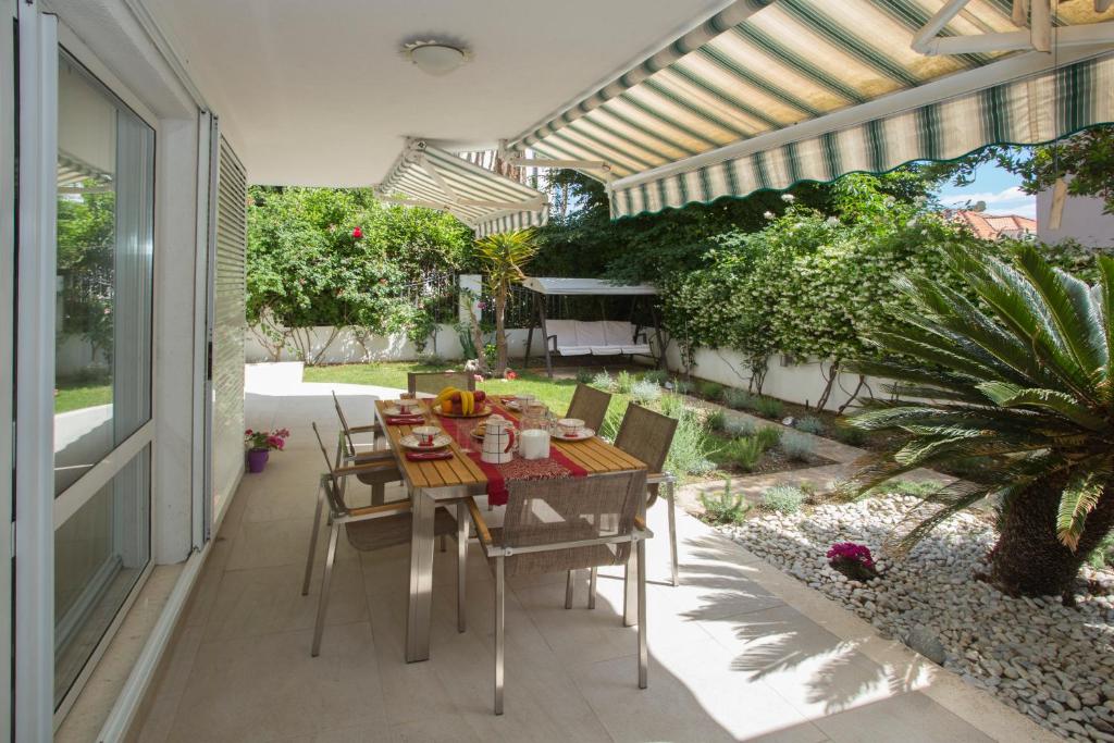 a patio with a table and chairs on a patio at Deluxe apartment Lea with large garden in Split