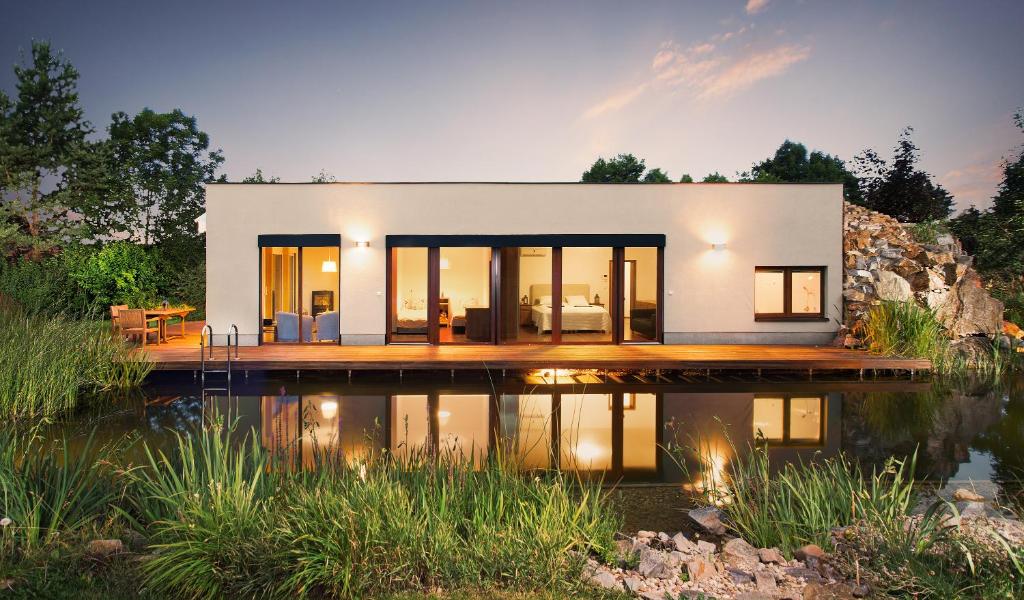 a modern house with a reflection in the water at Luxusní prázdninový dům in Rossitz