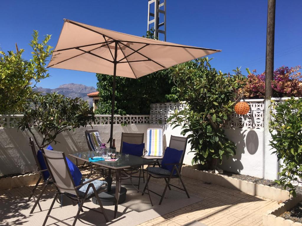 einen Tisch mit Stühlen und einem Sonnenschirm auf einer Terrasse in der Unterkunft Vista Bahia II Apartment in Albir