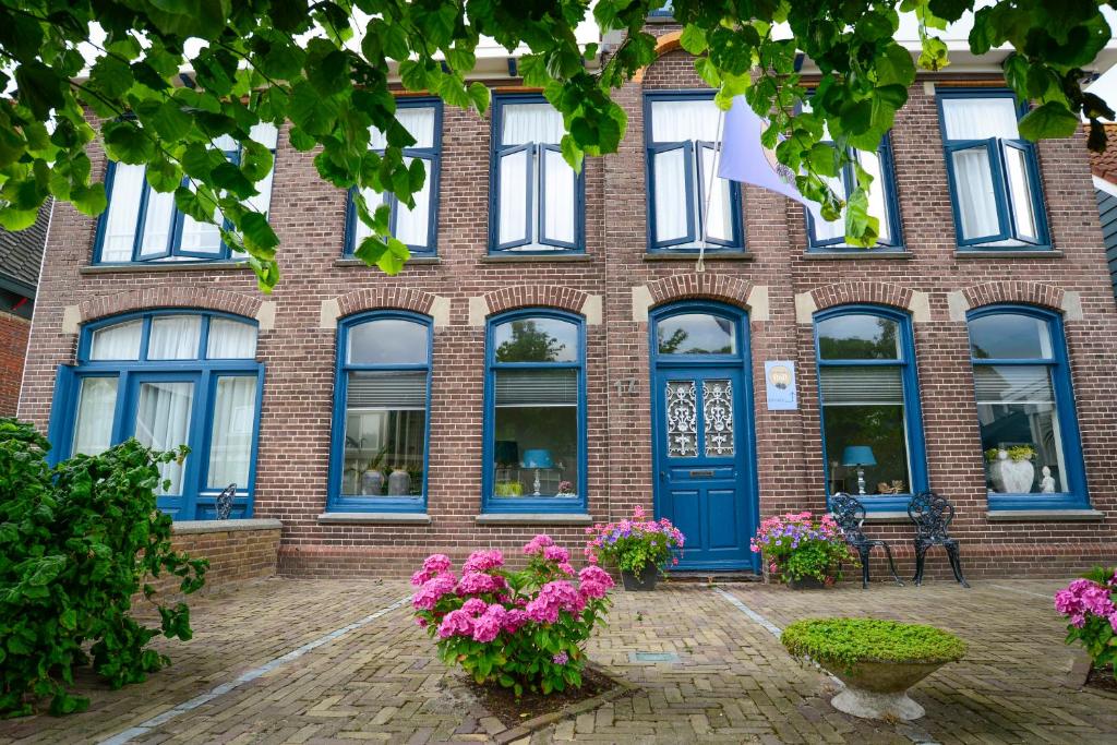 a brick building with blue doors and windows at De Moerbei in De Cocksdorp