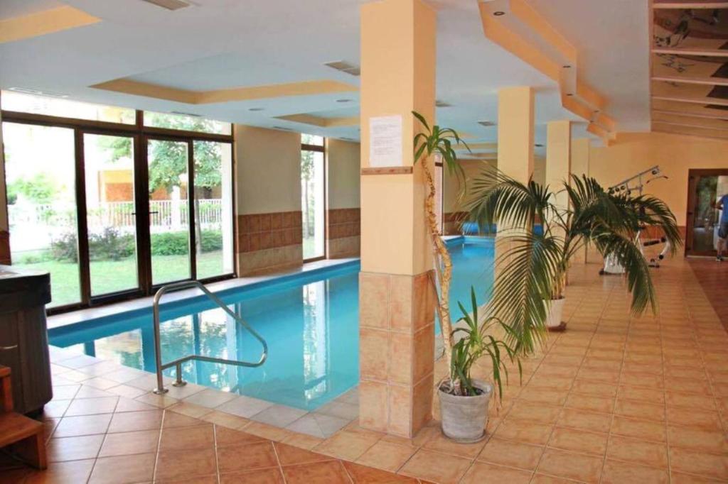 uma piscina num hotel com duas plantas num átrio em Levi's wellness apartman em Siófok