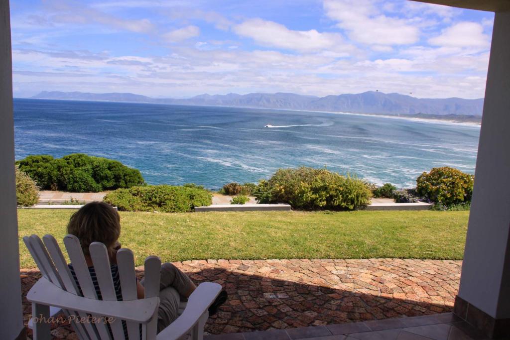 a child sitting in a chair looking at the ocean at WhaleTale in De Kelders