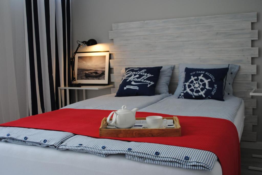 uma cama com uma bandeja com um conjunto de chá em Apartament Morski em Gdansk