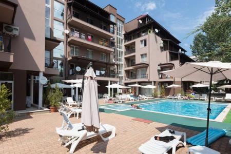 una piscina con due sedie e un ombrellone di Santa Sofia Studio a Sunny Beach