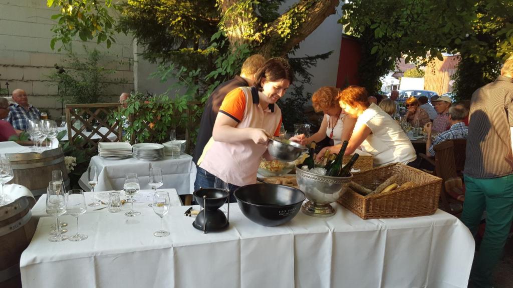Eine Gruppe von Menschen, die Essen auf einem Tisch zubereiten in der Unterkunft Landhotel Zur alten Post in Lohr