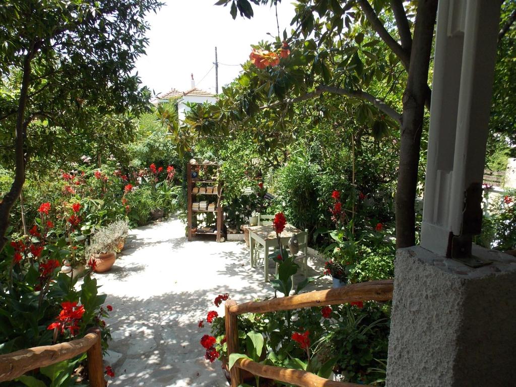 un jardín con flores rojas y un camino en Stamatia's Garden, en Agnontas
