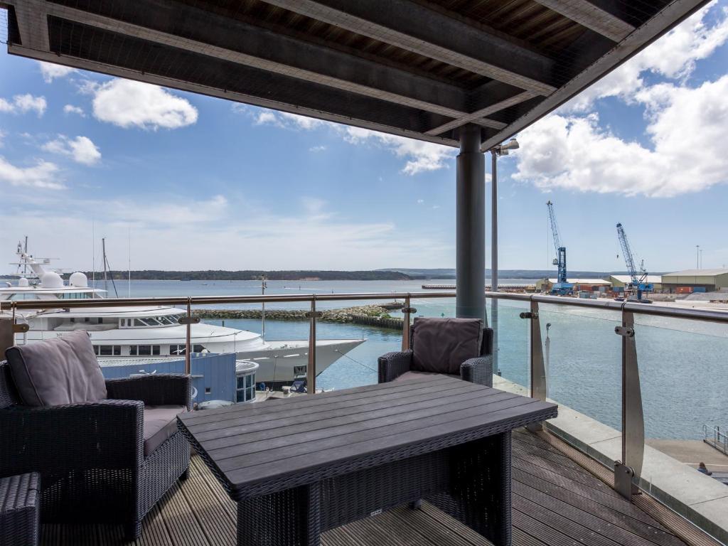 a deck with a wooden table and chairs and a boat at Panorama in Poole
