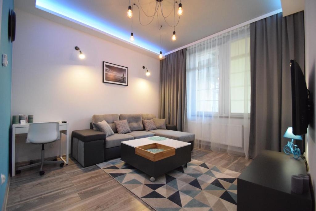 een woonkamer met een bank en een tafel bij MNE Apartament in Trzebiatów