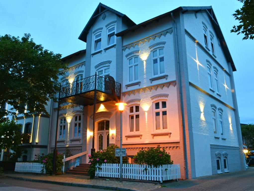 Una casa grande con luces en el lateral. en Pension Haus Lassen, en Westerland