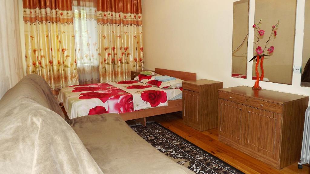 a bedroom with a bed and a mirror at Apartments on Logvinenko 26a in Bishkek