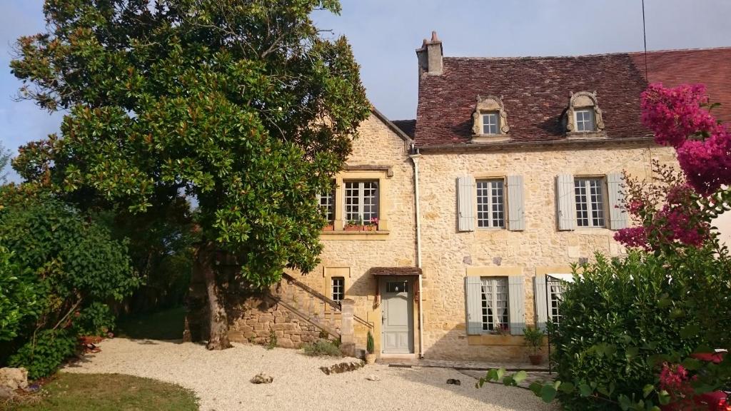 LalindeにあるRue du Châteauの木の前の古い石造家