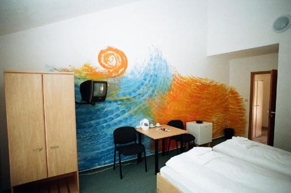 una stanza con una camera da letto con un letto e un tavolo di Motel Dacice a Dačice
