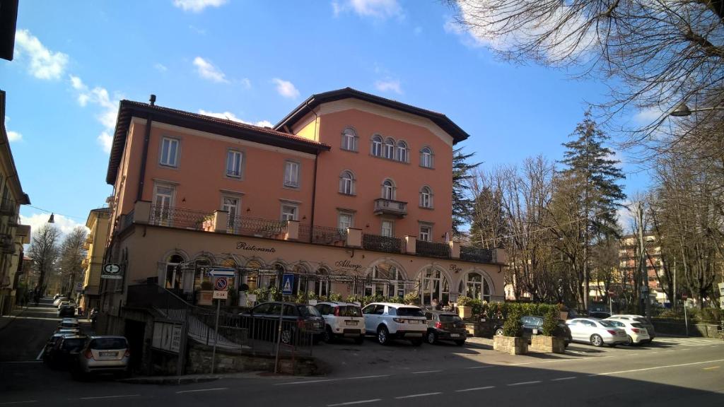 un grande edificio con macchine parcheggiate di fronte di Apartment Roma a Borgo Val di Taro