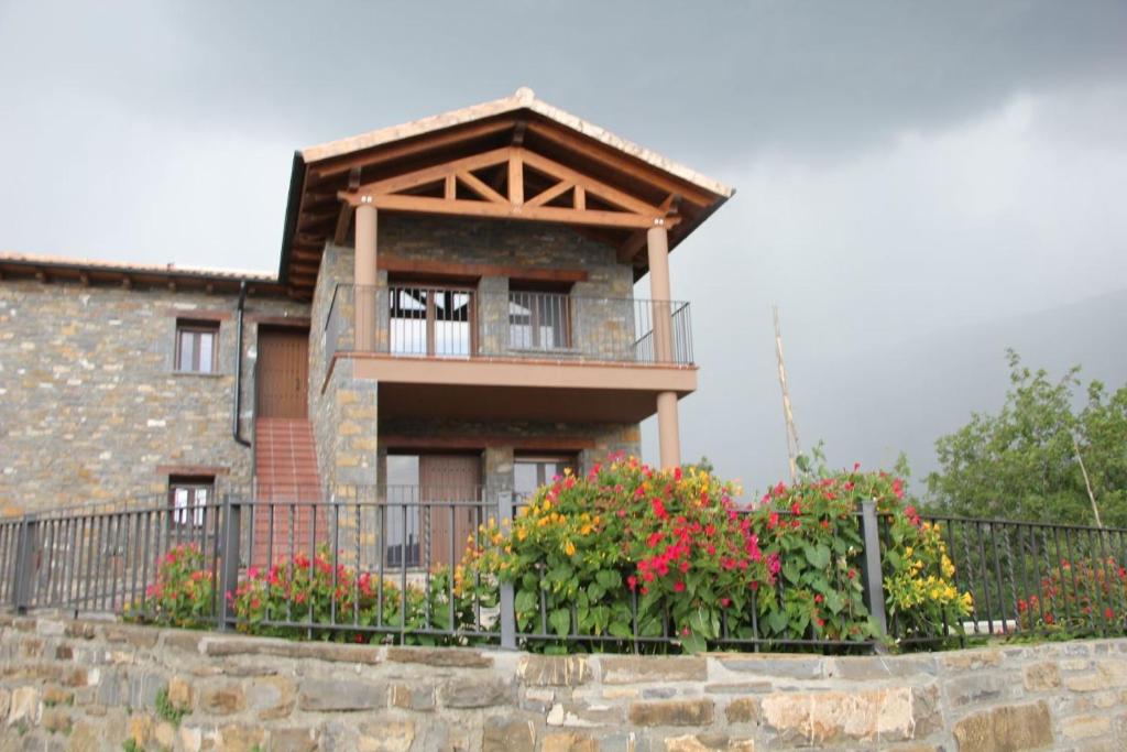 a house with a balcony and some flowers at Casa sierra ferrera in Samper