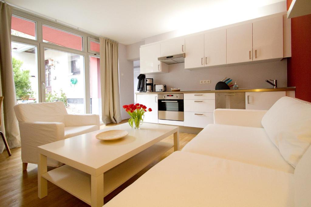 アーレンスホープにあるFerienwohnungen Auszeit und Freizeitのリビングルーム(白い家具、テーブル付)