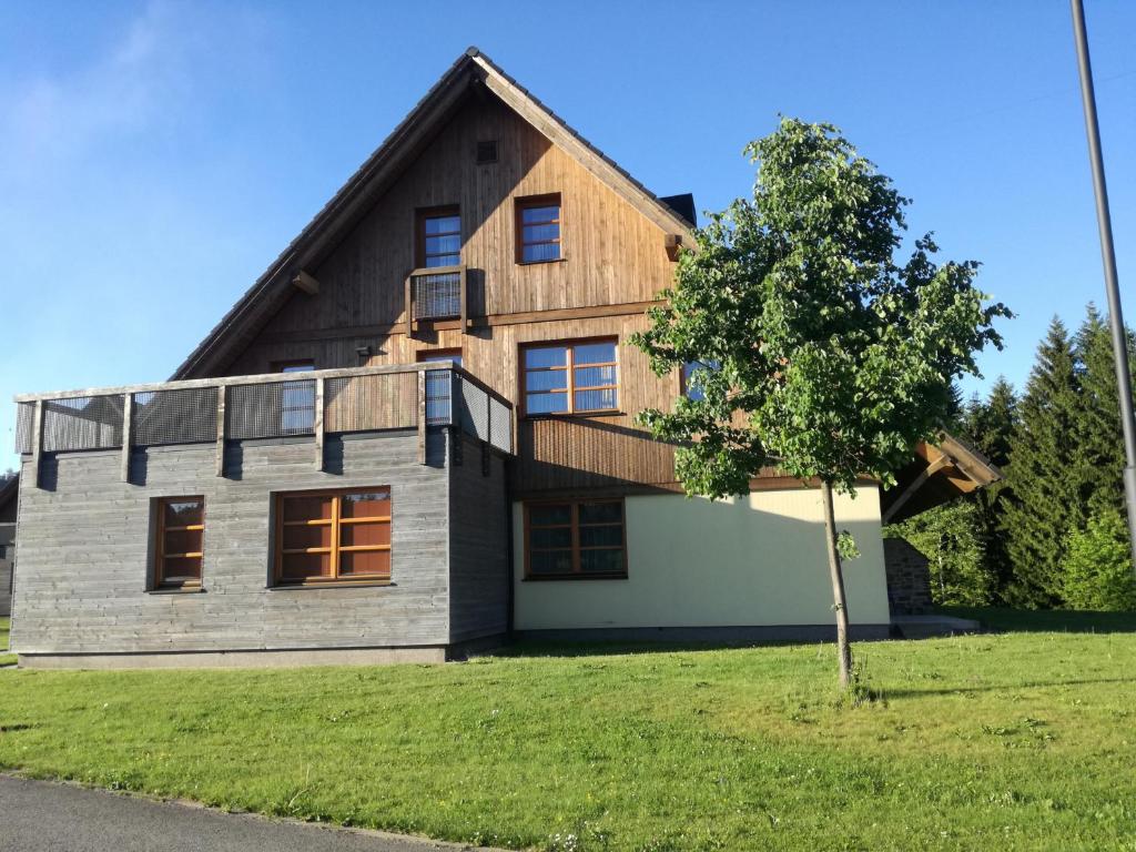 una casa con techo de madera y un árbol en Pohoda v Říčkách, en Říčky