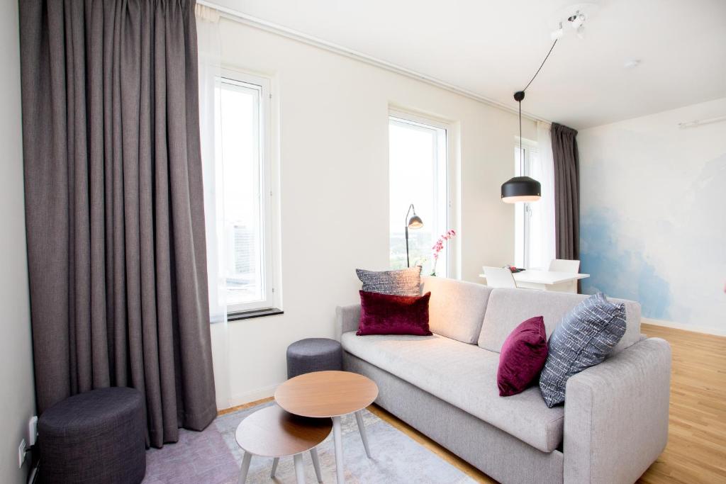 a living room with a couch and a table at ApartDirect Älvsjö in Stockholm