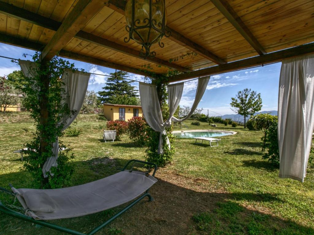 una hamaca bajo una pérgola en un patio en Belvilla by OYO Chalet Graffi, en Civitella dʼAgliano