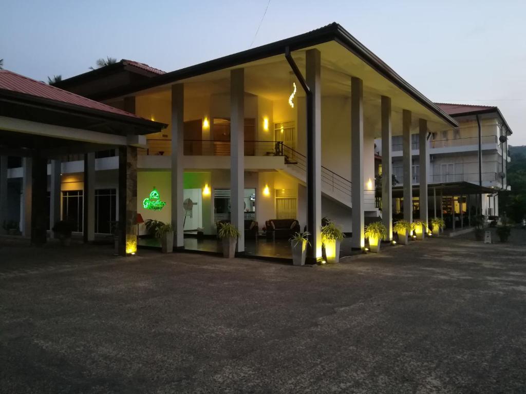 un edificio con colonne e luci in un parcheggio di Grindlays Regency ad Ambepussa