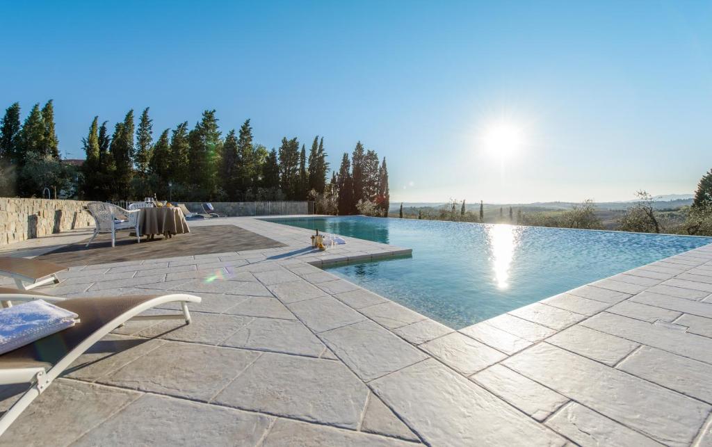 a large swimming pool with a stone patio at Agriturismo Il Principino in Vinci