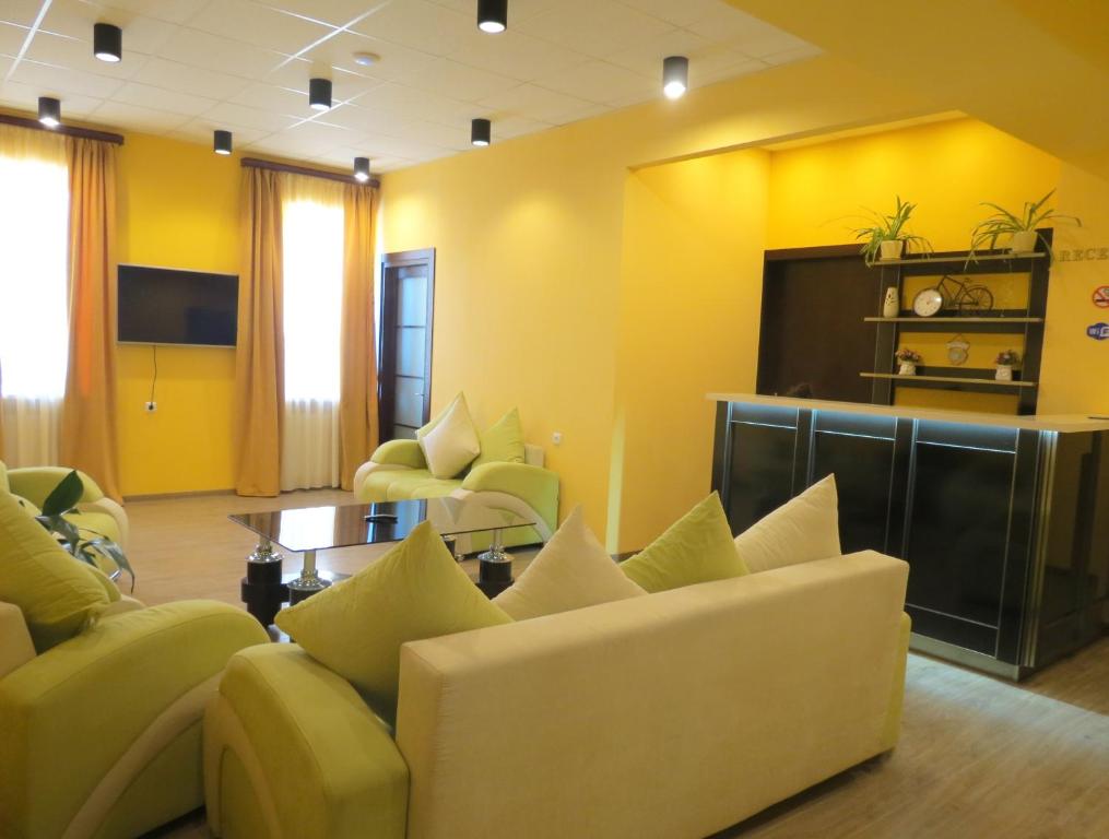 a living room with yellow walls and couches and a table at Your Home Hotel in Tbilisi City