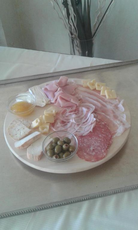 a plate with meat and other foods on a table at Hotel Banchetta in Sestriere