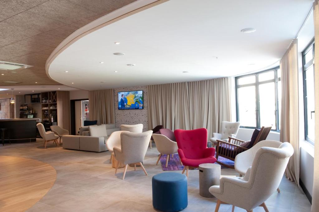 - une salle d'attente avec des chaises, des tables et un coin d'attente dans l'établissement Campanile Limoges Centre - Gare, à Limoges