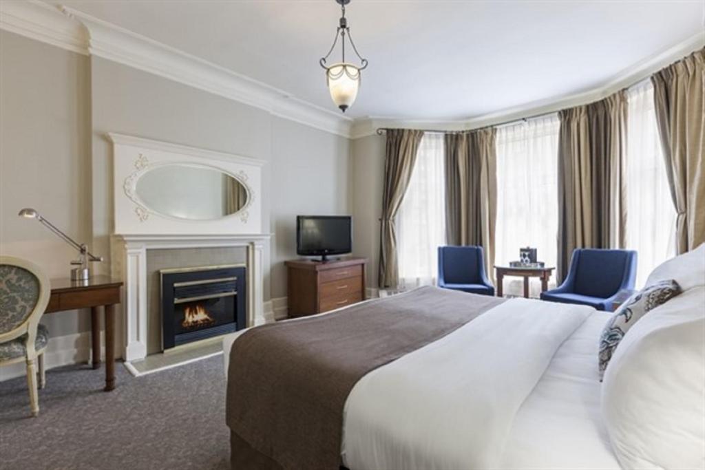 a hotel room with a bed and a fireplace at Chateau Versailles in Montréal