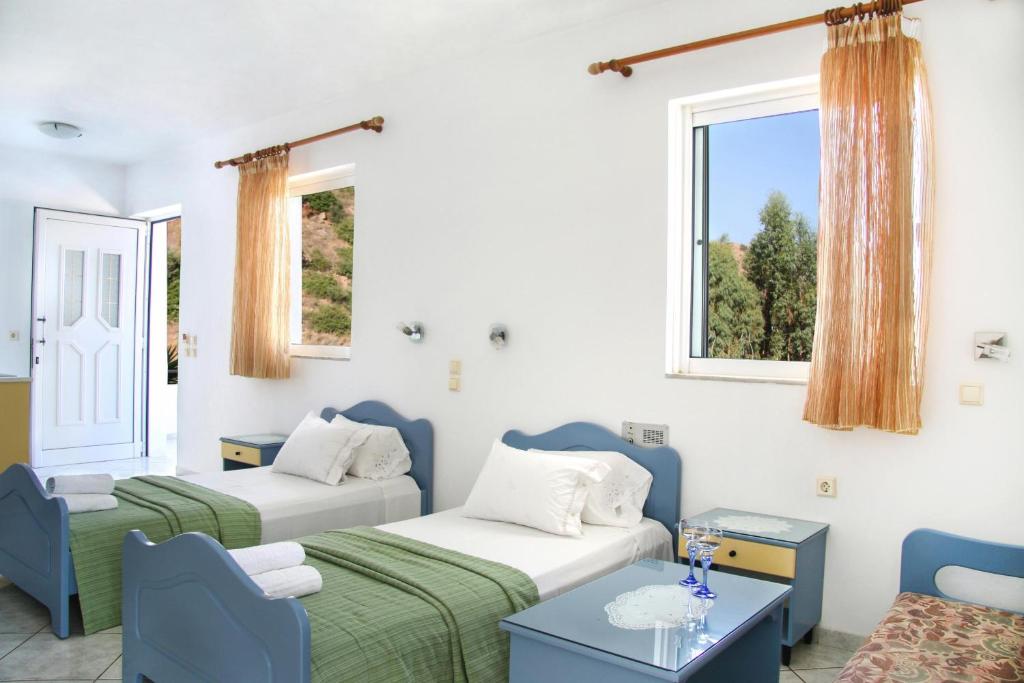 ロダキノにあるKleanthis Apartmentsのベッド2台、ソファ、窓が備わる客室です。