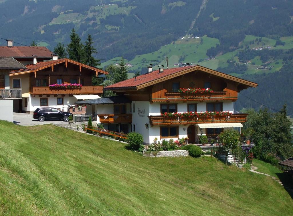 a house on top of a hill with a green field at Bloserhof Hauser in Zellberg