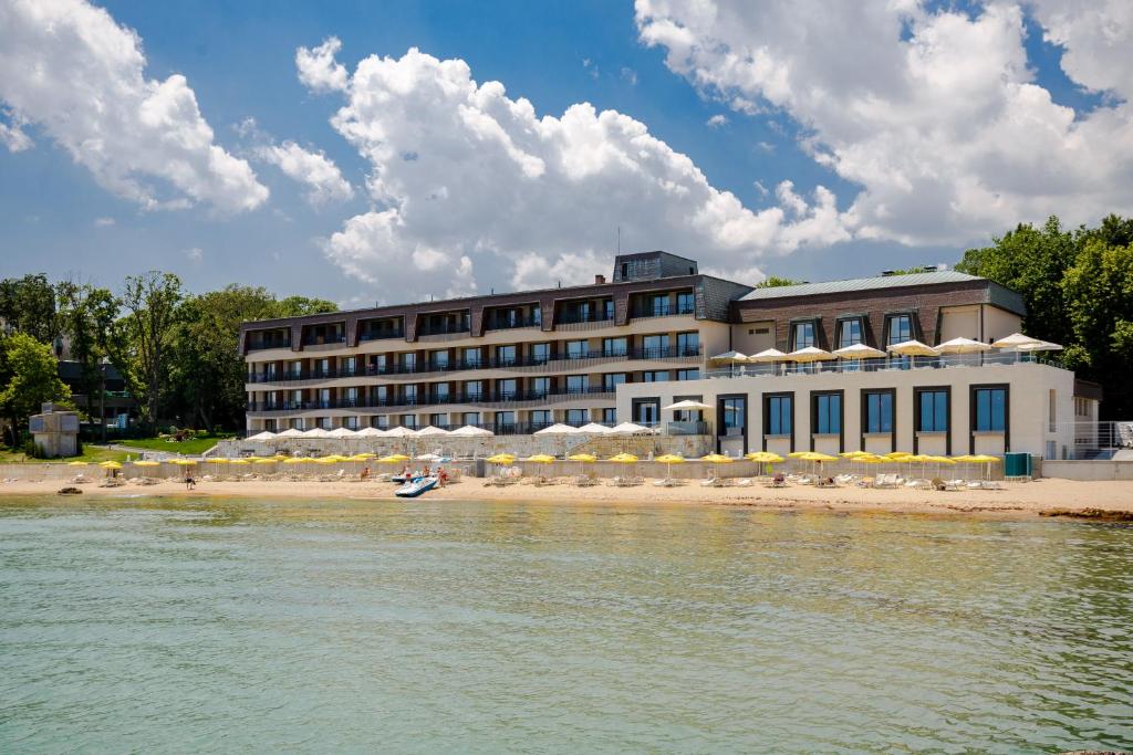 ゴールデン・サンズにあるNympha Hotel, Riviera Holiday Club - All Inclusive & Private Beachの水の海岸の建物