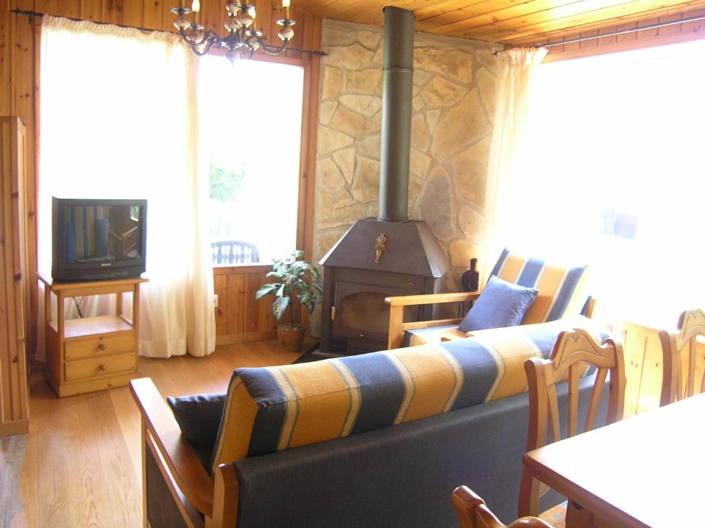 sala de estar con sofá y estufa de leña en Casa Ballarin ESPLUGA, en Espluga