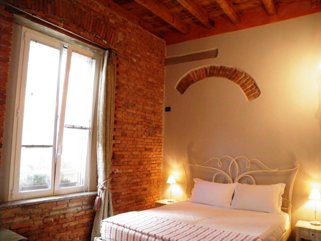 a bedroom with a bed and a brick wall at In Centro Charme in Bergamo