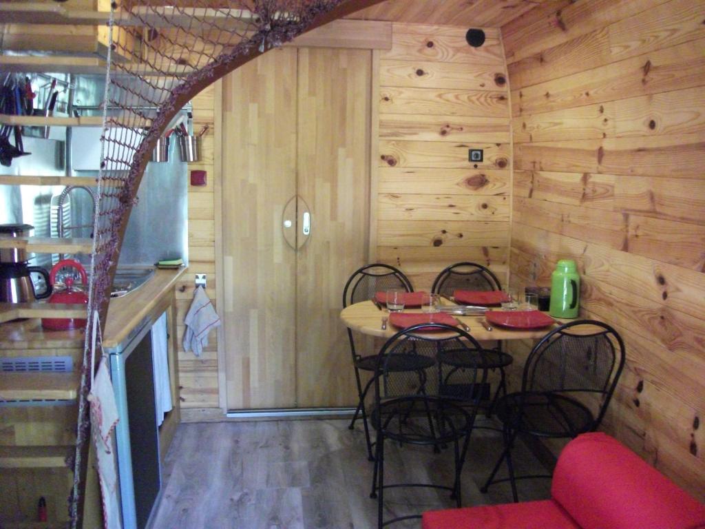 una cucina con tavolo e sedie in una casetta minuscola di Les Cahutes d'Olt a Saint-Laurent-dʼOlt